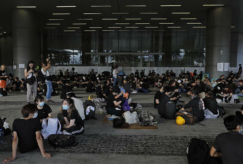 Activists rest outside the Legislative Council today in Hong Kong in advance of planned protests over extradition legislation that has yet to be withdrawn despite their demands.