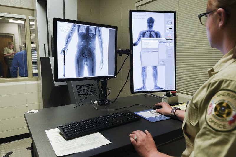 Safety radiation officer Tiffany Devore operates a body scanner Thursday at the Benton County sheriff’s office in Bentonville.