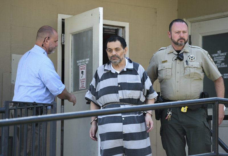 NWA Democrat-Gazette/CHARLIE KAIJO Mauricio Torres is escorted Friday out of the Benton County Courthouse Annex in Bentonville. Torres had his arraignment Friday as he faces a second trial for killing his 6-year-old son. The state Supreme Court overturned his 2016 conviction in the case.