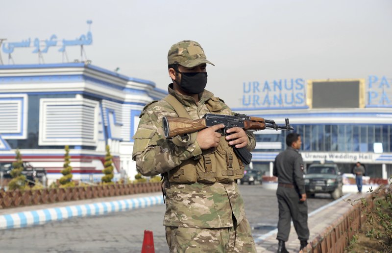 In this Nov. 21, 2018 file photo, an Afghan security officer stands guard outside a wedding hall in Kabul, Afghanistan. A lack of coordinated oversight of America's spending in Afghanistan has led to a waste of funds and hampered training and development of the country's security forces, according to a watchdog group that monitors billions of dollars in U.S. aid to the country. (AP Photo/Rahmat Gul)