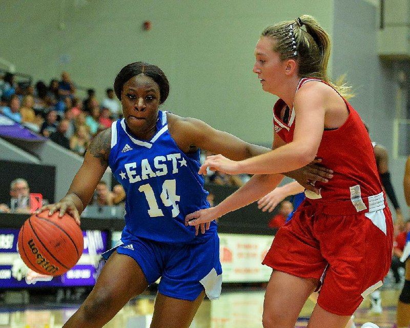 The East’s Mya Love (left) of Nettleton drives past the West’s Abby James of Pottsville during Saturday’s Arkansas High School Coaches Association Girls All-Star basketball game at the Farris Center in Conway. Love, who was named the MVP, had 15 points, 5 rebounds and 5 steals to lead the East to an 85-72 victory. 