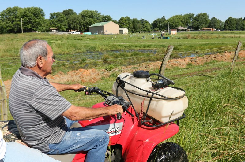 NWA Democrat-Gazette/DAVID GOTTSCHALK Lawrence Bowen rides the fence line June 13 on his property. His land borders Bethel Heights' Lincoln Street Waste Water Treatment Plant. Bowen says tests show sewage has run onto his property.