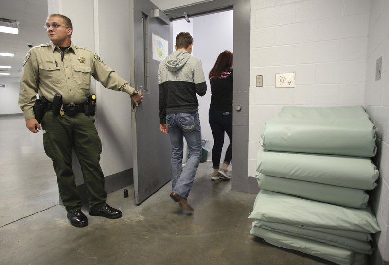 File Photo/NWA Democrat-Gazette/DAVID GOTTSCHALK Sgt. Seth Partain with the Washington County Sheriff's Office holds the door Nov. 16, 2017, for West Fork High School students touring at the Washington County Detention Center in Fayetteville. Sheriff Tim Helder said he shares concerns about overcrowding and will work with the justices, other elected officials and members of the community to examine ways to reduce the jail population.