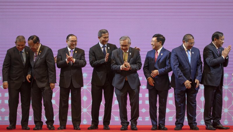 From left, Malaysia Foreign Minister Saifuddin Abdullah, Myanmar Minister of State for Foreign Affaires Kyaw Tin, Philippines Foreign Affaires Secretary Teodoro Locsin Jr., Singapore Foreign Minister Vivian Balakrishnan, Thailand Foreign Minister Don Pramudwinai, Vietnam Foreign Minister Pham Binh Minh, Brunei Second Minister of Foreign affaires and Trade Erywan Yusof, and Cambodia Foreign Minister Prak Sokhonn clap after posing for a group photo during the Association of Southeast Asian Nations (ASEAN) Foreign Ministers' meeting in Bangkok, Thailand, Saturday, June 22, 2019. (AP Photo/Gemunu Amarasinghe)