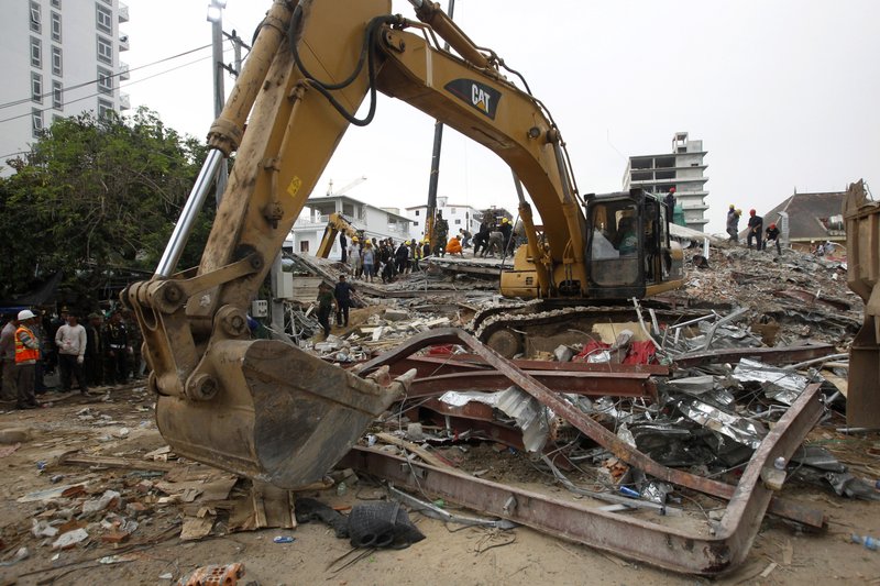 An excavator remove the rubble at the site of a collapsed building in Preah Sihanouk province, Cambodia, Saturday, June 22, 2019. Rescue work at the site was underway to find out if any more workers were trapped in the rubble of the seven-story building under construction. (AP Photo/Heng Sinith)