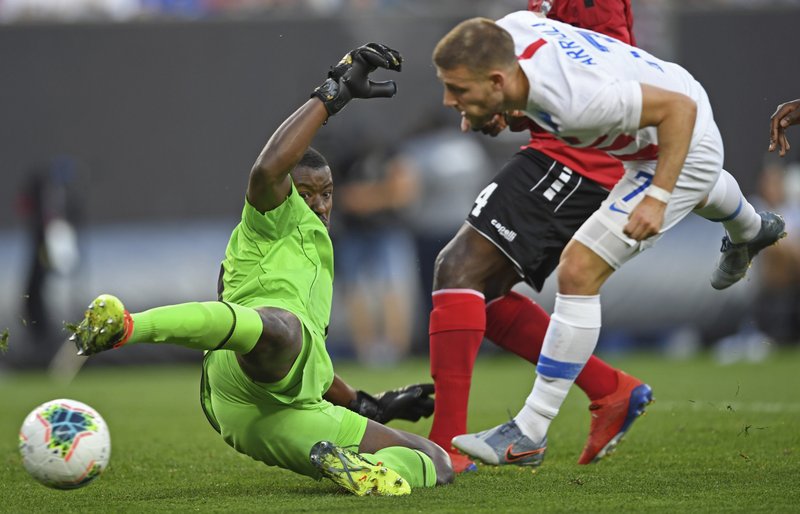 Trinidad and Tobago goalkeeper Marvin Phillip deflects the ball after a shot by U.S. forward Paul Arriola during the first half of a CONCACAF Gold Cup soccer match Saturday, June 22, 2019, in Cleveland. (AP Photo/David Dermer)