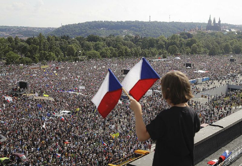 A child waves Czech flags Sunday during the largest anti-government protest in almost 30 years in Prague, Czech Republic. Demonstrators called on Prime Minister Andrej Babis to step down over fraud allegations involving European Union funds and concerns he might undermine the independence of the Czech legal system. 