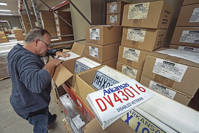 Arkansas Democrat-Gazette/MITCHELL PE MASILUN Tag-room supervisor Brett Davis fulls fulfills an order for a state revenue office's order at the Department of Finance and Administration's central storage area in Little Rock.