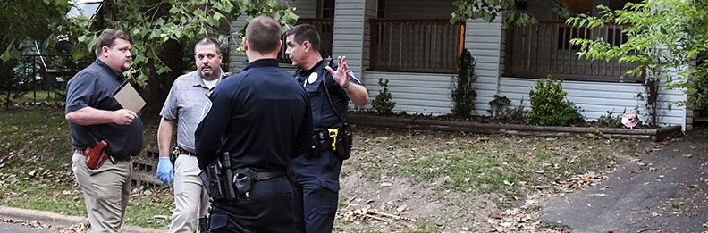 The Sentinel-Record/Grace Brown CRIME SCENE: Detectives and officers with the Hot Springs Police Department discuss a fatal shooting at 315 N. Patterson St. at the scene Saturday evening.