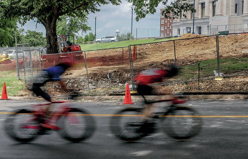 Arkansas Democrat-Gazette/JOHN SYKES JR. Cyclists participating in the Arkansas State Criterium Championships at the Arkansas state Capitol on Saturday speed past where the Gold Star Families Memorial Monument is being built on the west side of the building.