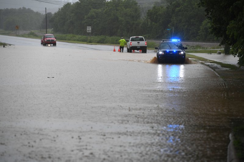 NWA Democrat-Gazette/J.T. WAMPLER Greenland police officer Clayton Wagnon drives through flood water after the west fork of the White River forced closure of U.S. 71 Sunday June 23, 2019. Much of Northwest Arkansas was under a flood watch most of the day Sunday due to continued heavy rainfall.