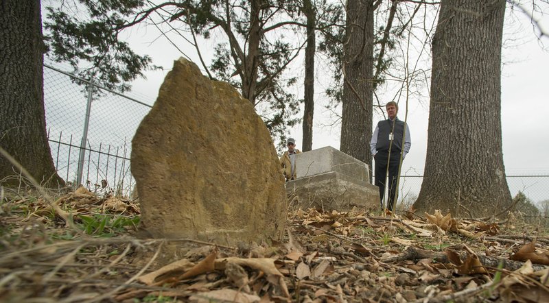 File photo/NWA Democrat-Gazette/J.T. WAMPLER Mark Renfroe, facilities maintenance crew leader and Wade Abernathy, division manager for facilities and construction management Fayetteville, look over old headstones in the cemetery at the Woolsey farmstead at South Broyles Avenue in west Fayetteville. The Planning Commission on Monday forwarded rezoning the property, which will allow the city to carry out the project, to the City Council.