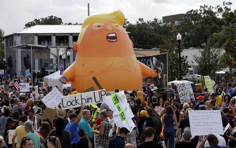 An inflatable Baby Trump balloon towers over protestors during a rally Tuesday, June 18, 2019, in Orlando, Fla. A large group was protesting against President Donald Trump was rallying near where Trump was announcing his re-election campaign. President Trump is being trolled by an angry diaper-clad caricature armed with a cell phone. It&#x2019;s Baby Trump, the blimp that has become synonymous with resistance to the American president. The balloon has been cloned multiples times over and become something of a celebrity _ for at least one slice of the U.S. electorate. He&#x2019;s also emerged as a rallying point for supporters of the president who see the blimp as evidence of just how over-the-top the opposition has become.(AP Photo/Chris O'Meara)