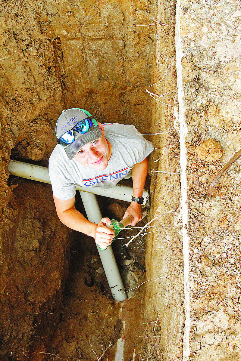 Pipe work: Hudson McDiarmid of Glenn Mechanical descends into a trench dug in front of the Barton Public Library. The library is having its old sewer lines, which are a clay, tile and cast iron mix, replaced with modern PVC piping.