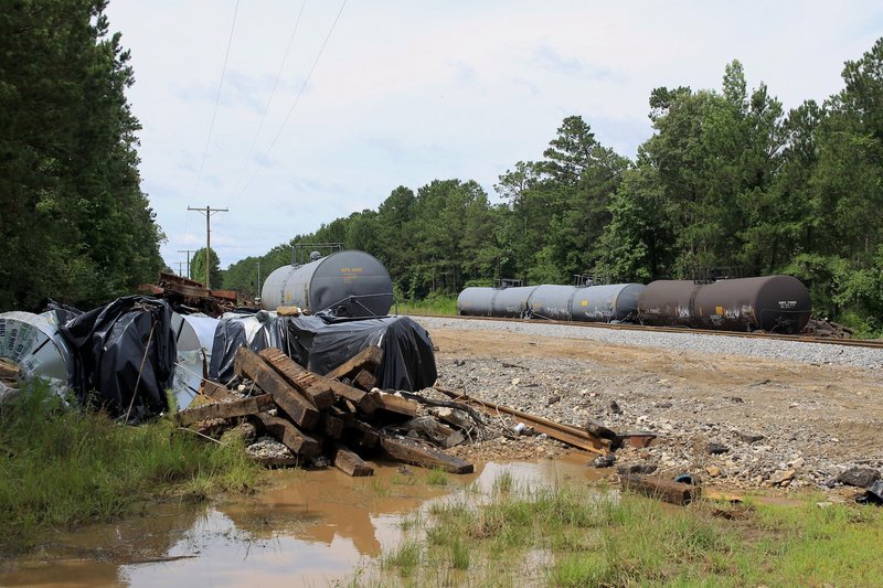 Tanker cars and materials sit beside the railroad tracks at the Gaddy Koonce Road railroad crossing in Jefferson County following the derailment of a Union Pacific train Saturday night. Sheriff's office officials said the crossing was supposed to have been repaired by Monday but that heavy thunderstorms that moved through the area Sunday delayed repair efforts.