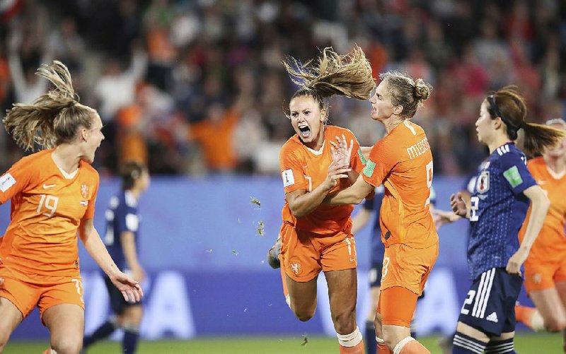 Lieke Martens (left) and Vivianne Miedema of the Netherlands celebrate after Martens’ second goal, which came on a penalty kick, during Tuesday’s 2-1 victory over Japan in the knockout stage of the Women’s World Cup in Rennes, France. 