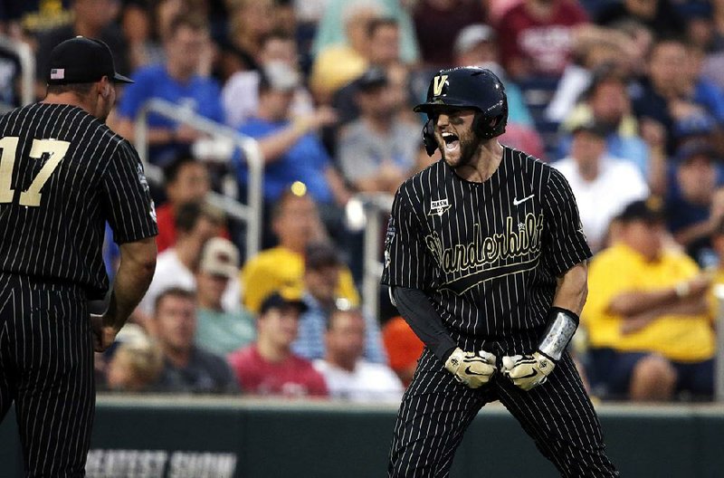Vanderbilt’s Philip Clarke (right) celebrates with teammate Walker Grisanti after crossing home plate following his home run in the seventh inning of the Commodores’ victory over Michigan on Tuesday night in Game 2 of the College World Series Championship Series. The teams meet tonight to determine the national champion. 