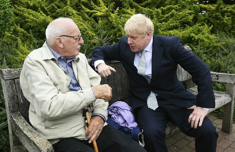 Boris Johnson (right), a candidate to lead Britain’s governing Conservative Party, talks to a visitor Tuesday as he tours the Royal Horticultural Society garden at Wisley, England. 