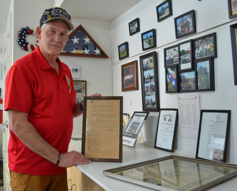 Herald-Leader/Sierra Bush Siloam Springs American Legion Post 29 Commander Stuart Reeves showcases the application for charter by the original 15 members of the SSAL in 1919.