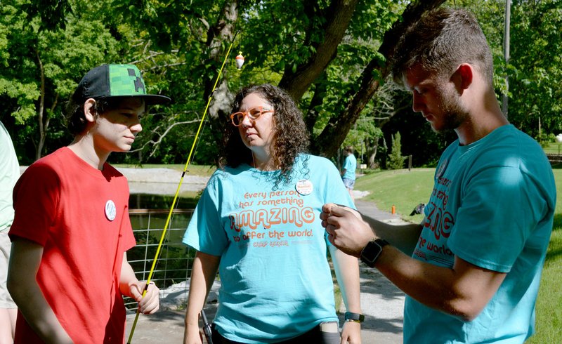 Sierra Bush/Herald-Leader Camp Acacia founder Rachel Smith, center, speaks with a camper, left, and a camp counselor, right, before the camper returns to the creek to catch another fish. Smith founded the camp in 2018 as a personal project to create a summer camp experience for children with mental, physical and emotional disabilities.