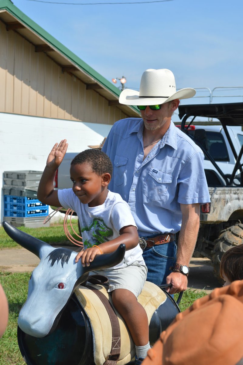 Sierra Bush/Herald-Leader Keagan Robinson practices his bull riding skills during the Siloam Springs Rodeo Friday. The Siloam Springs annual rodeo hosted a time for children with special needs Friday to feed animals, pet animals and ride horses.