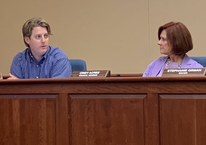 Tim Robinson, council member, (left) gives an update on the Pet Resource and Services Steering Committee to the Bentonville City Council Tuesday as Cindy Acree, council member, (right) listens on.