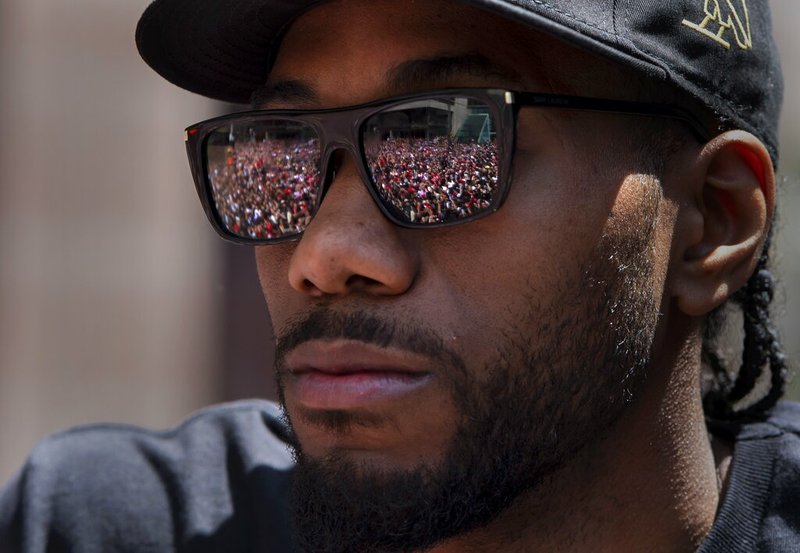 Cheering fans are reflected in the sunglasses of Toronto Raptors' Kawhi Leonard during the team's NBA basketball championship parade in Toronto, Monday, June 17, 2019. (Frank Gunn/The Canadian Press via AP)