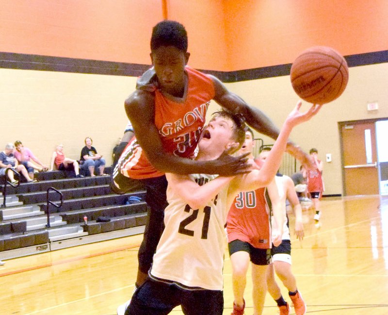 Michael Duke gets caught off guard as a Grove player goes over Duke's head during the Gravette-Grove junior varsity basketball game in the old gym at Gravette High School June 18. Grove took the win in the final five seconds of the second half, 31-29 over the Lions, during the Gravette Summer League.