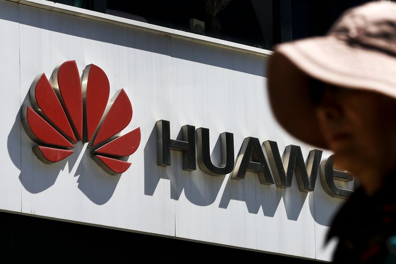 In this May 29, 2019, file photo, a woman walks by a Huawei retail store in Beijing. A federal jury in Texas rejected Wednesday, June 26, 2019, claims by Chinese telecom-equipment maker Huawei Technologies that Silicon Valley start-up CNEX stole its trade secrets. (AP Photo/Andy Wong, File)