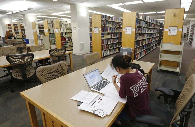 In this June 20, 2019, photo a student works in the library at Virginia Commonwealth University in Richmond, Va. Those who graduate college with student loans owe close to $30,000 on average, according to the most recent data from the Institute for College Access &amp; Success. (AP Photo/Steve Helber)