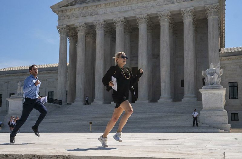 News interns run from the Supreme Court on Thursday with copies of the justices’ decisions. 