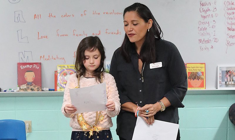 The Sentinel-Record/Richard Rasmussen POEMS FOR ALL: Poet Kai Coggin, right, listens as first-grade student Kara Bice reads her poem at the Cutter Morning Star Summer Reading Camp Thursday.
