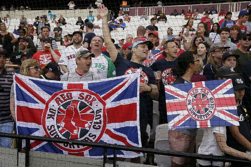 Fans watch the Boston Red Sox take batting practice Friday in London. Today’s game between the Red Sox and the New York Yankees will be the first major league contest held in Europe. 