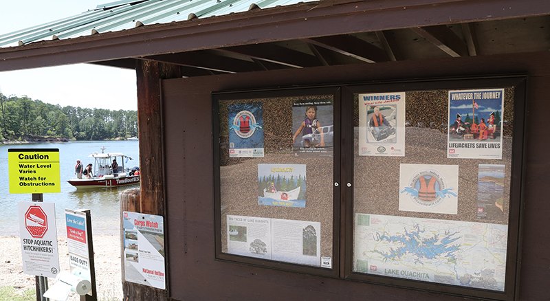 The Sentinel-Record/Richard Rasmussen SAFETY FIRST: A boat pulls up to the Brady Mountain Recreation Area boat ramp near a bulletin board with water safety information Thursday. The U.S. Army Corps of Engineers is stressing boaters and swimmers take extra precautions over the holiday weekend while on Lake Ouachita.