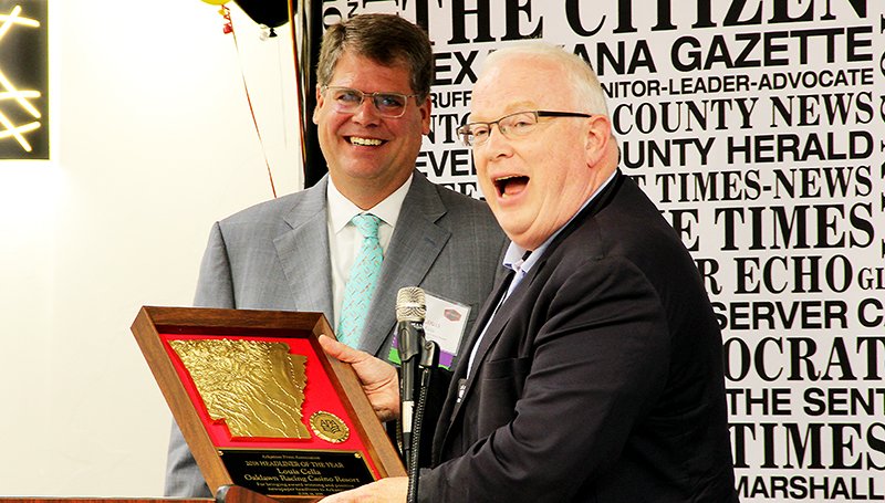 The Sentinel-Record/Mark Gregory HEADLINER OF THE YEAR: Rex Nelson, right, a senior editor at the Arkansas Democrat-Gazette, shares a light moment as he presents Louis Cella, president of the Oaklawn Jockey Club, with the 2019 Headliner of the Year award on behalf of the Arkansas Press Association on Friday at The Hotel Hot Springs &amp; Spa.