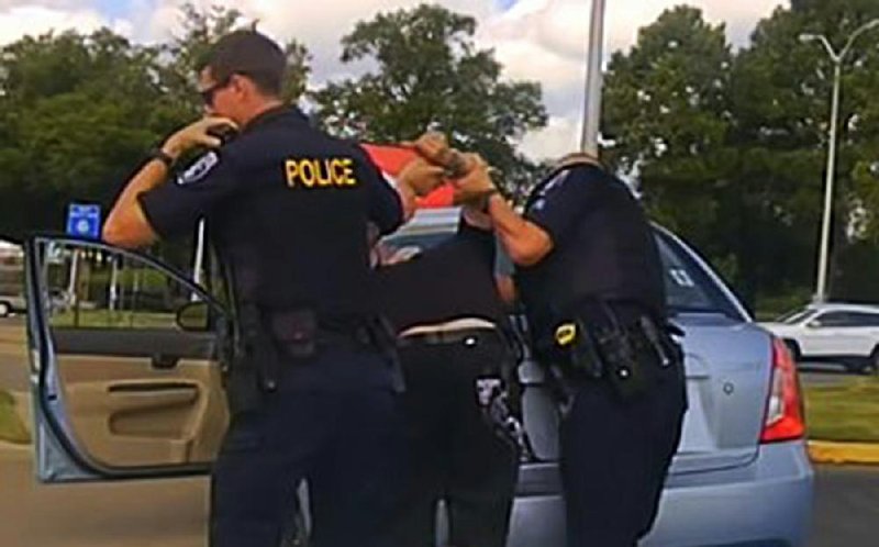 A frame grab from dashboard-camera video released by the North Little Rock Police Department shows officer Jon Michael Crowder (right) and Kristopher Ryan Lamar on Aug. 27. 