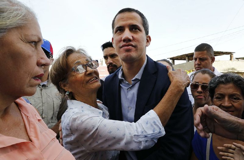 Supporters surround Venezuelan opposition leader Juan Guaido as he arrives Saturday for a commemorative Mass in La Guaira, the capital of Vargas state in northern Venezuela. 