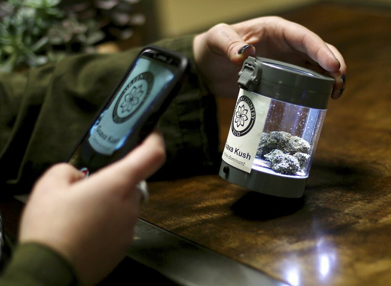 In this Feb. 27, 2019 photo, an employee at Green Country Bud photographs a marijuana flower for a social media post in Tulsa, Okla. When Oklahomans voted one year ago in favor of State Question 788, officials thought about 80,000 patients, or about 2% of the state’s estimated population, would register in the first year of a legal medical marijuana program. As of June 24, the Oklahoma Medical Marijuana Authority has already registered more than 3.5% of the population as patients, with little sign of applications slowing. (John Clanton/Tulsa World via AP)