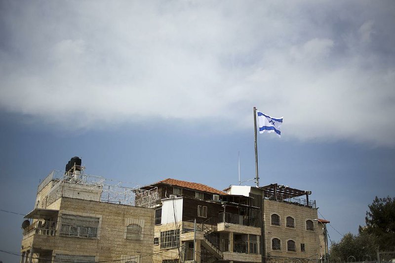 An Israeli flag flies on a building in east Jerusalem in March. The number of settlers in the West Bank and east Jerusalem has grown to 700,000 people since Israel captured those areas in 1967.