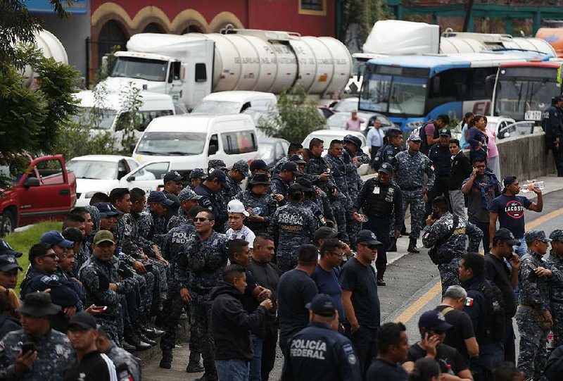 Federal police officers in Ecatepec, Mexico, block the highway Wednesday between Mexico City and Pachuca in both directions as they protest plans to assign them to the National Guard. 
