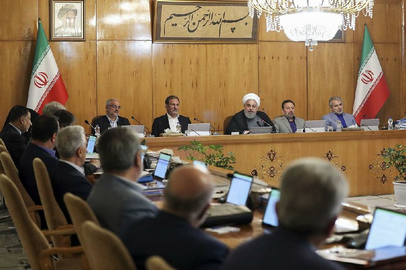 Iranian President Hassan Rouhani (third from right) speaks during a Cabinet meeting Wednesday in Tehran. During the session, Rouhani said Iran would move Sunday to enrich uranium to higher levels “in any amount that we want, any amount that is required.” 