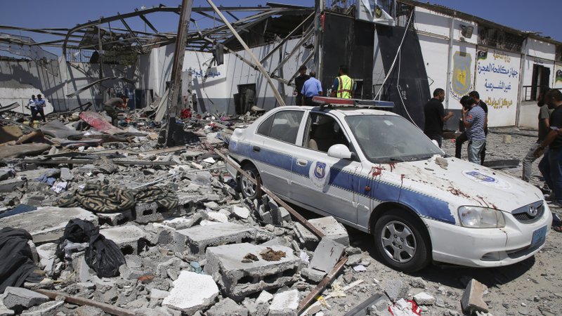 Debris covers the ground and an emergency vehicle after an airstrike at a detention center in Tajoura, east of Tripoli in Libya, Wednesday, July 3, 2019. An airstrike hit the detention center for migrants early Wednesday, killing several.  (AP Photo/Hazem Ahmed)