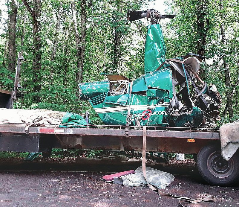  A wrecked Tulsa County Helicopter sits June 6 on a flatbed trailer on Arkansas 23 in Franklin County. Three people were killed June 2 and one was injured in the helicopter crash near Mulberry Mountain north of Ozark, according to officials.