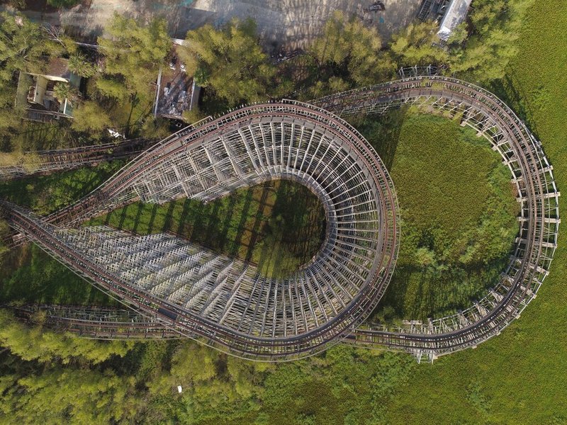 In this June 22, 2019 aerial photo, a roller coaster and concession buildings of the abandoned Six Flags Great Adventure Amusement Park are seen in New Orleans. The abandoned New Orleans amusement park that has stood empty since Hurricane Katrina in 2005 may finally be torn down. The Six Flags park never reopened after the levees failed and flooded the city with water. Mayor LaToya Cantrell says her office is targeting the site for demolition. (DroneBase via AP)