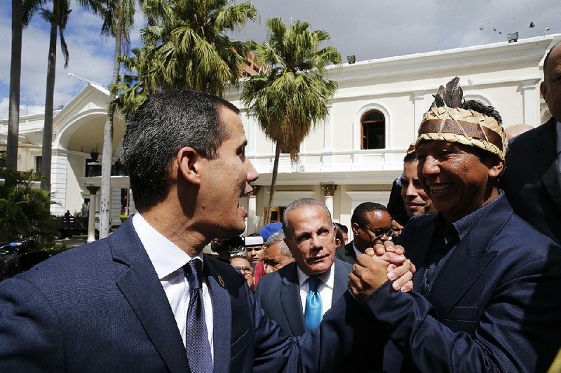 Venezuelan opposition leader Juan Guaido greets lawmaker Romel Edgardo Guzamana as he arrives Friday at the National Assembly in Caracas to take part in an Independence Day ceremony. 