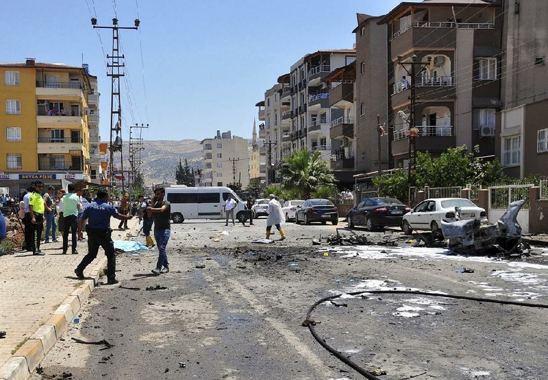 Turkish officials investigate the explosion Friday of a bomb in a car that was carrying three Syrians in the border town of Reyhanli. 