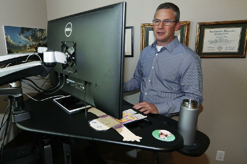 Software manufacturer Joe Wilson works from his home recently in Highlands Ranch, Colo. He says ripple effects from U.S. tariffs mean he might have to delay some hiring. 