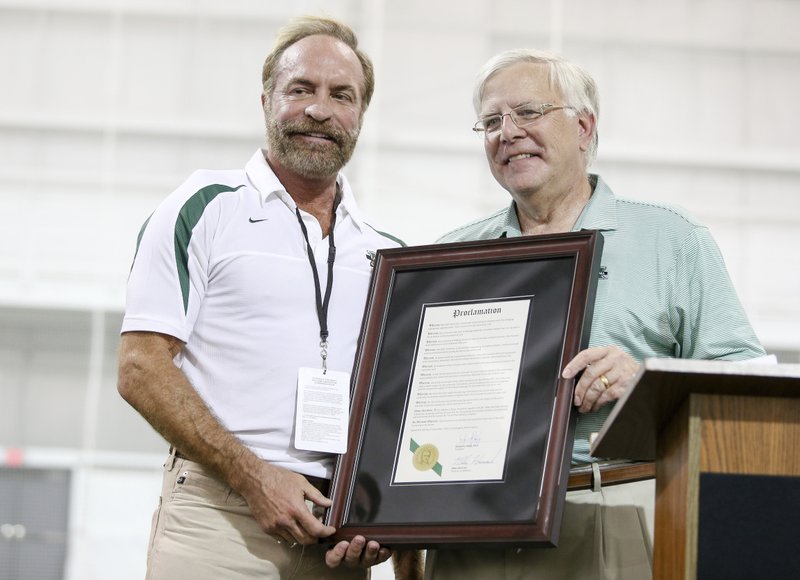 In this Sept. 6, 2014 photo, President Stephen Kopp, right, congratulates Chris Cline as Marshall University dedicates the new indoor practice facility as the Chris Cline Athletic Complex in Huntington, W.Va. (Sholten Singer/The Herald-Dispatch via AP)