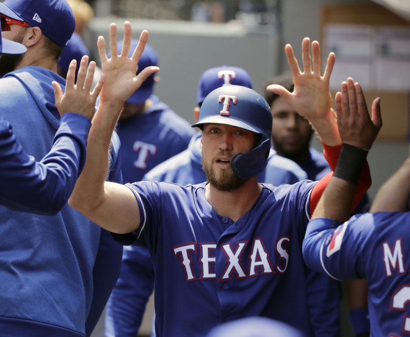 FILE - In this May 29, 2019, file photo, Texas Rangers' Hunter Pence is greeted in the dugout after he scored on an RBI single hit by Asdrubal Cabrera during the first inning of a baseball game in Seattle. Pence was being wished well in retirement last year. Next week, he'll be at the All-Star Game representing the Rangers. (AP Photo/Ted S. Warren, File)
