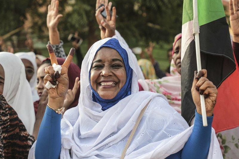 A Sudanese woman celebrates in the streets of Khartoum after ruling generals and protest leaders announced they have reached an agreement on the disputed issue of a new governing body on Friday, July 5, 2019.  The deal raised hopes it will end a three-month political crisis that paralyzed the country and led to a violent crackdown that killed scores of protesters. (AP Photo)